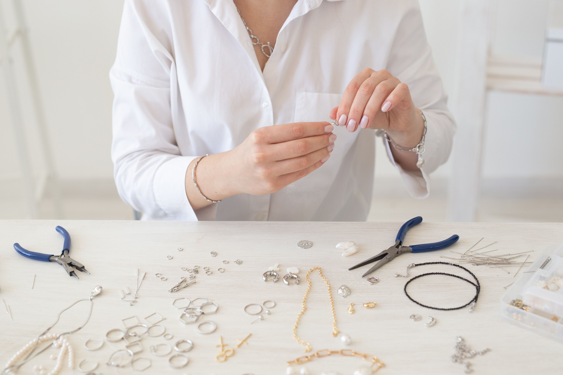 Close-up of professional jewelry designer making handmade jewelry in studio workshop close-up. Fashion, creativity and handmade concept